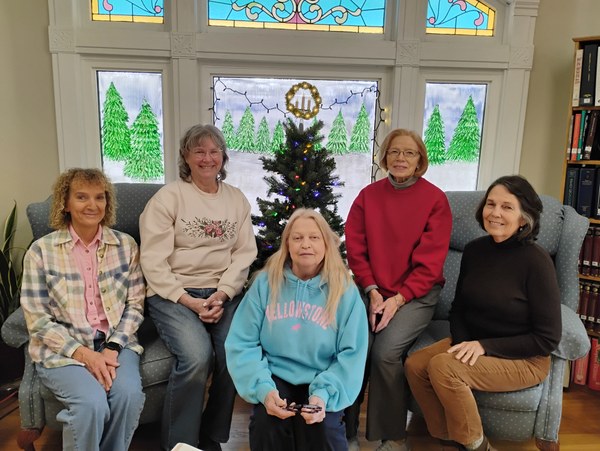 The 2025 Board of Trustees sitting in front of a Christmas tree.